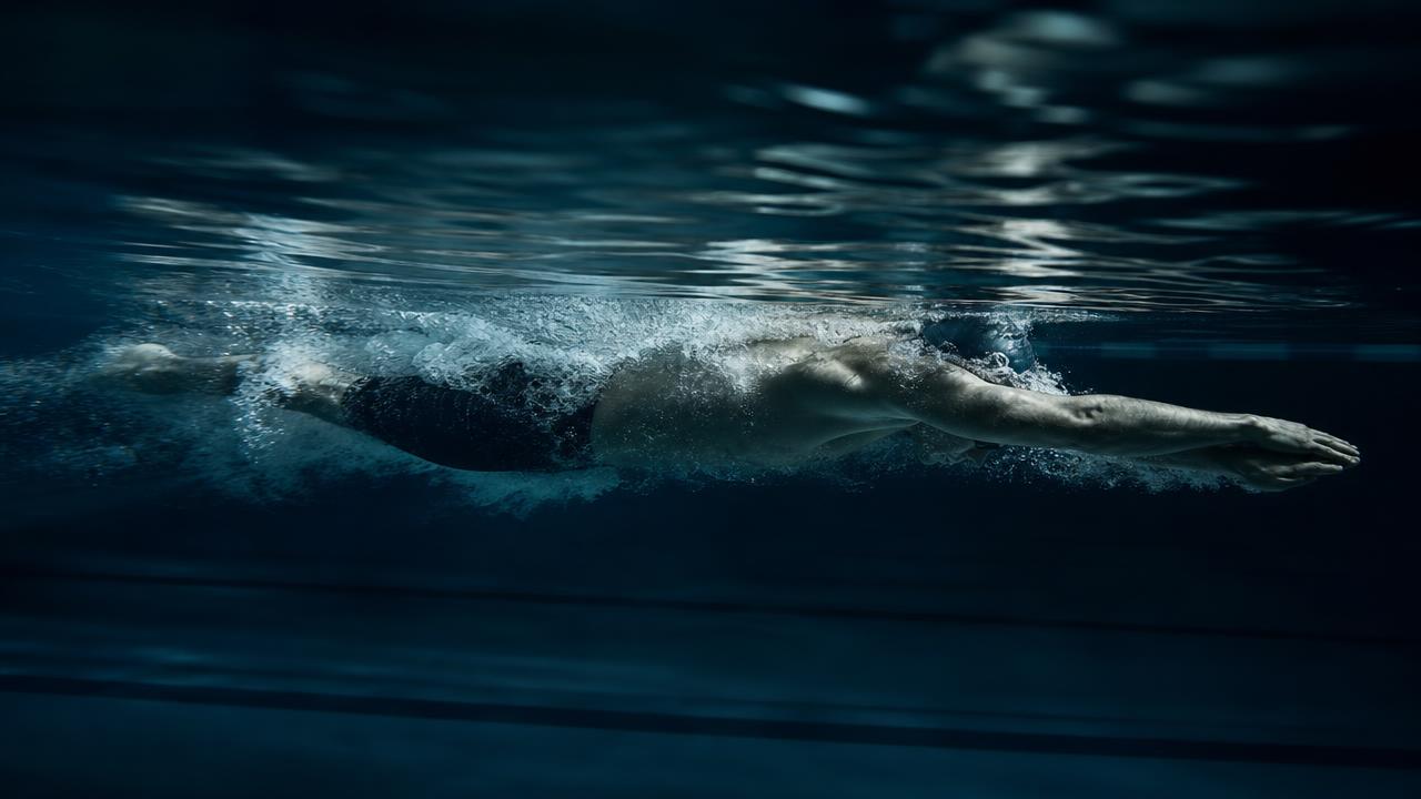 Competitive swimmer underwater in streamlined position